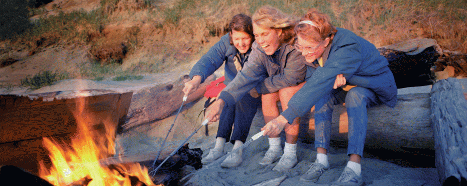 3 women roasting food in the bonfire
