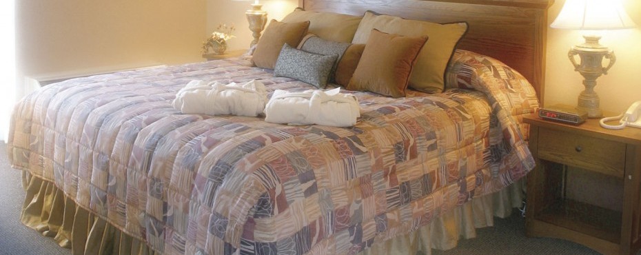 Large King Bed with lots of pillows and two robes